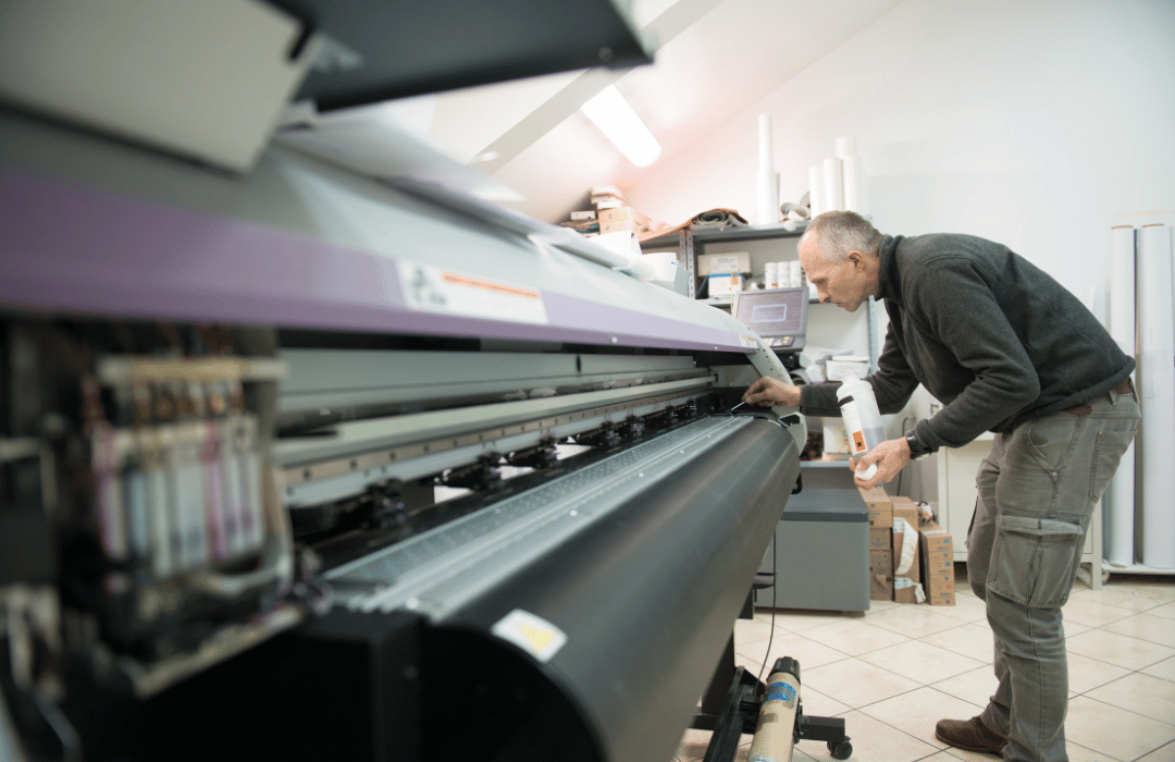 Manual cleaning of a printer head using isopropyl alcohol and lint-free cotton swabs to prevent clogs and improve print quality